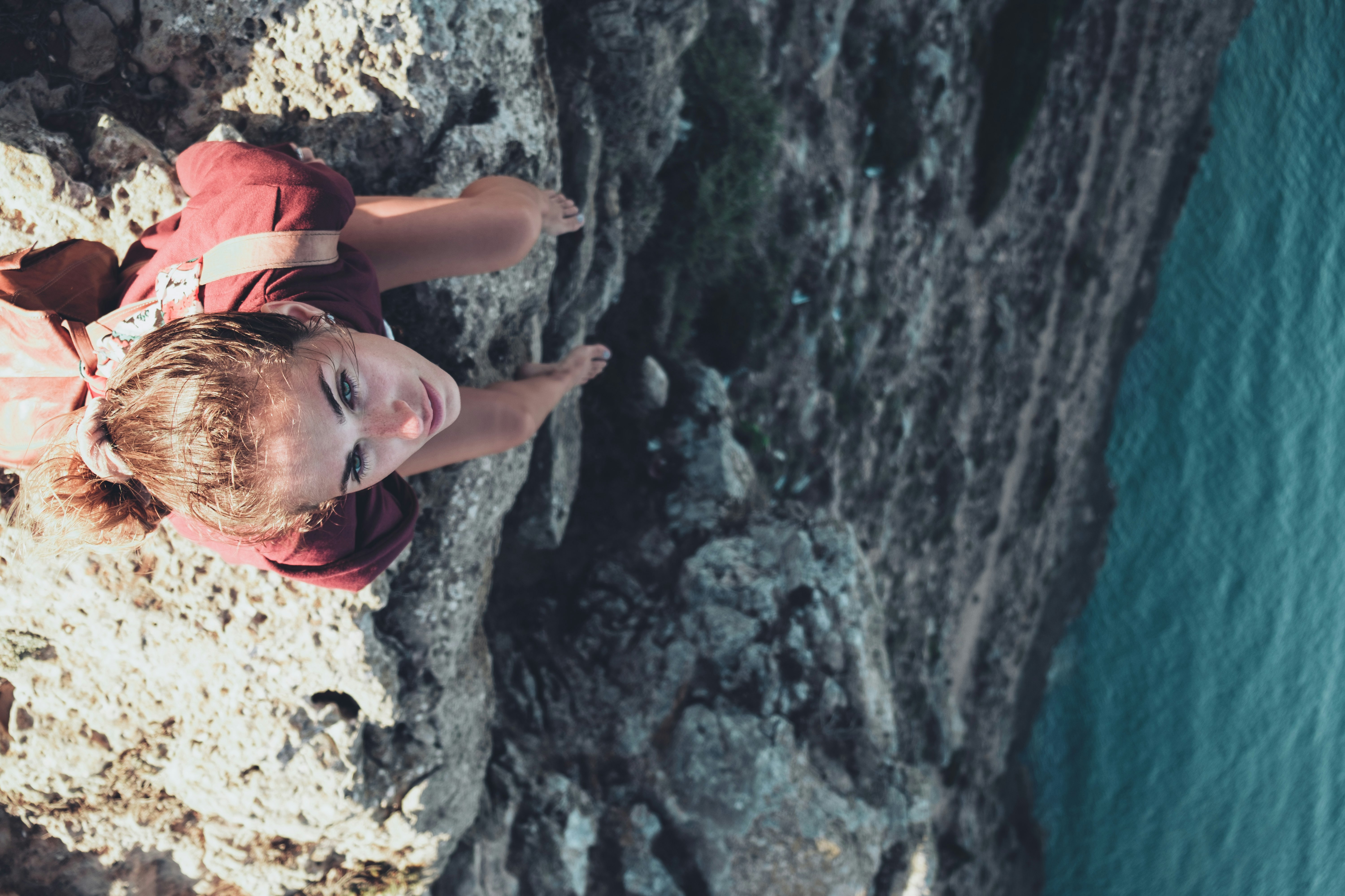 woman sitting on mountain cliff